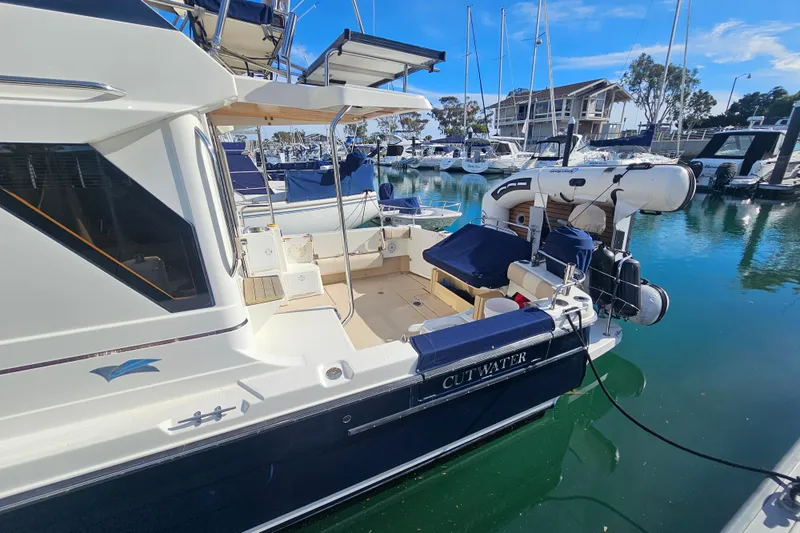 Slide: The Image of 2015 Cutwater 30 Command Bridge yacht docked in a marina, featuring a spacious deck. - 5