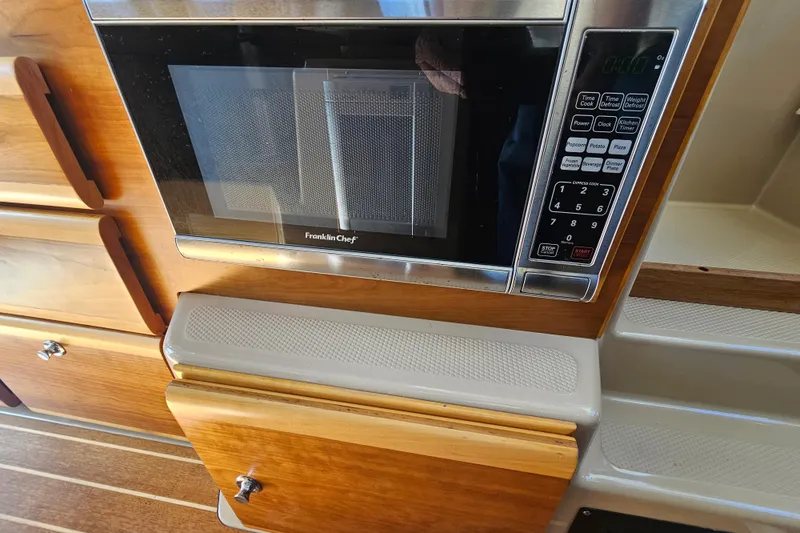Slide: The Image of Microwave in 2015 Cutwater 30 Command Bridge kitchen with wooden cabinetry. - 52