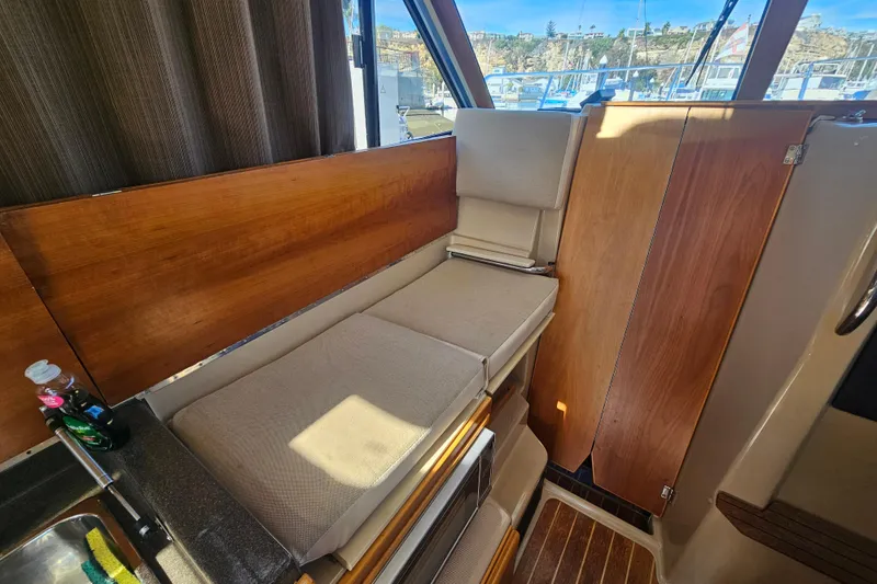 Slide: The Image of Interior of 2015 Cutwater 30 Command Bridge with cushioned seating and wooden accents. - 54