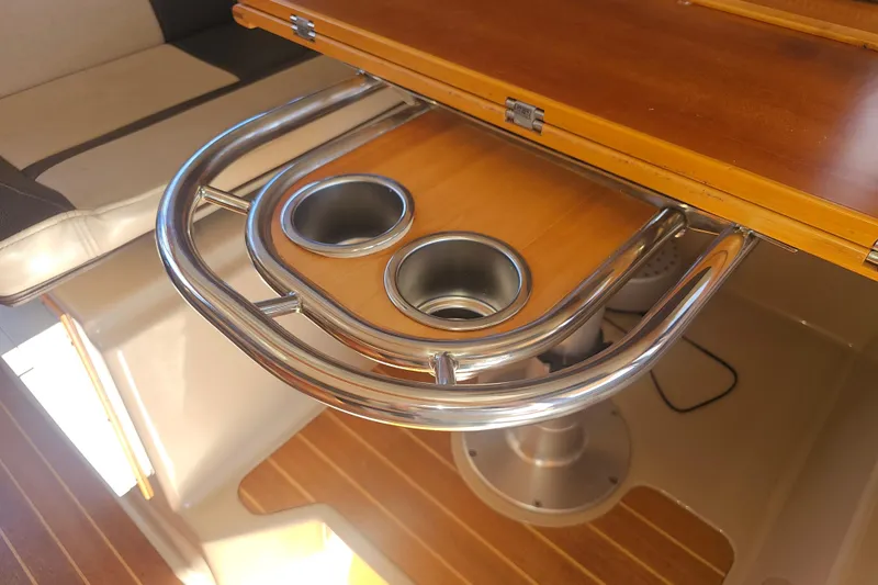 Slide: The Image of Interior of 2015 Cutwater 30 Command Bridge with wooden table and cup holders. - 55