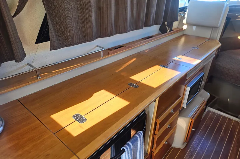 Slide: The Image of Interior of 2015 Cutwater 30 Command Bridge with wooden cabinetry and appliances. - 56