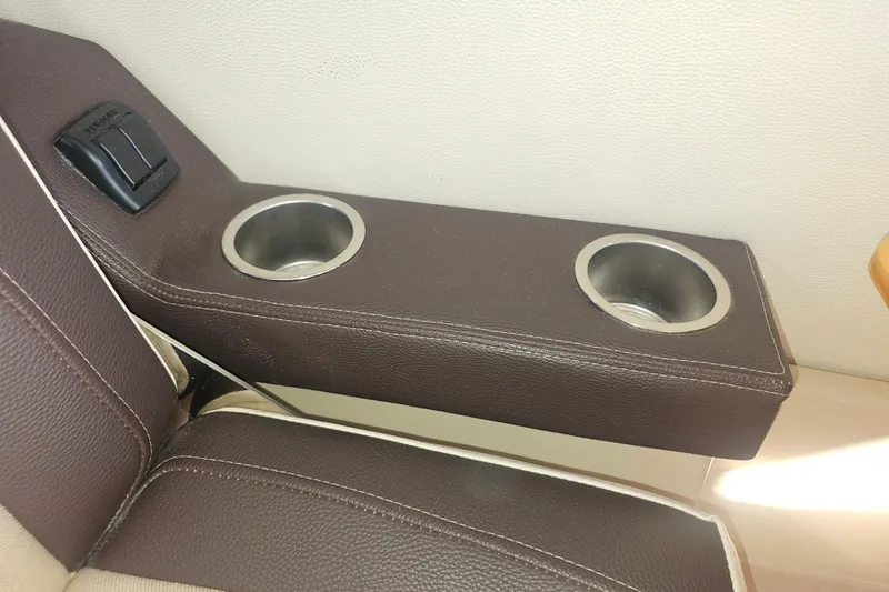 Slide: The Image of Brown leather armrest with dual cup holders in a 2015 Cutwater 30 Command Bridge. - 59