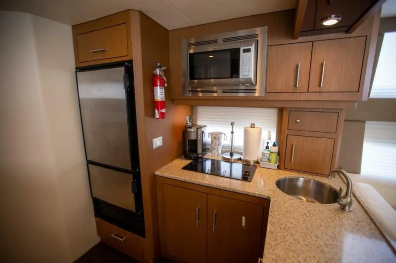 Slide: The Image of Compact kitchen in 2012 Carver Sojourn yacht with modern appliances and wood cabinetry. - 6