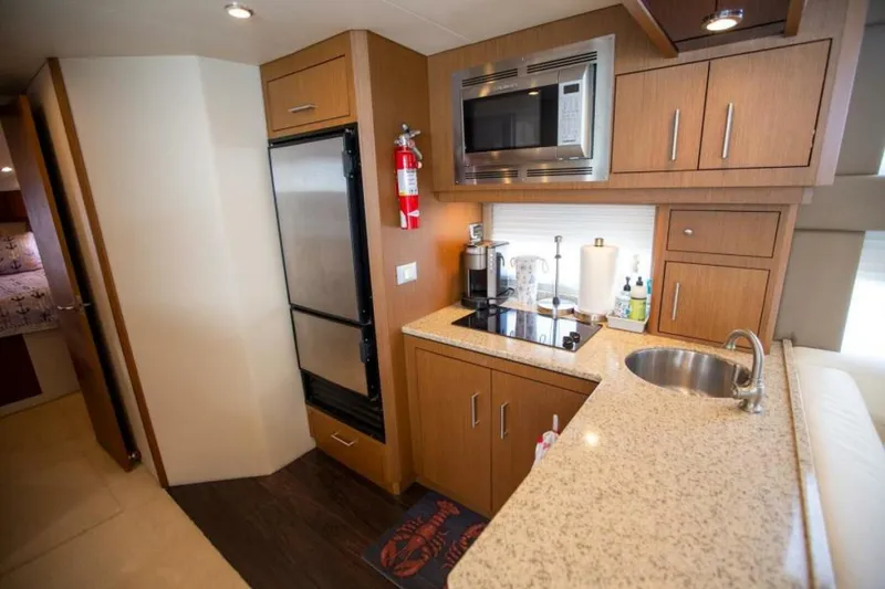 Slide: The Image of Compact kitchen in 2012 Carver Sojourn yacht with modern appliances and wood cabinetry. - 12