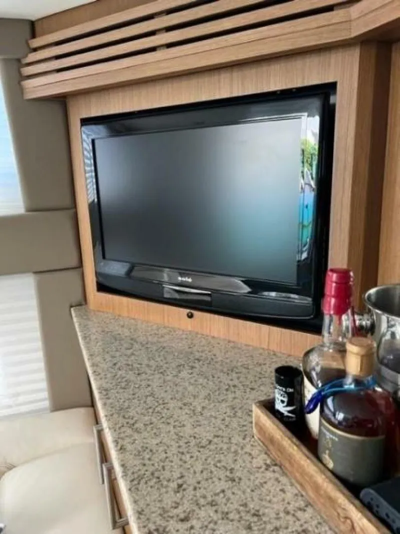 Slide: The Image of Flat-screen TV in 2012 Carver Sojourn yacht interior with granite countertop and liquor bottles. - 30