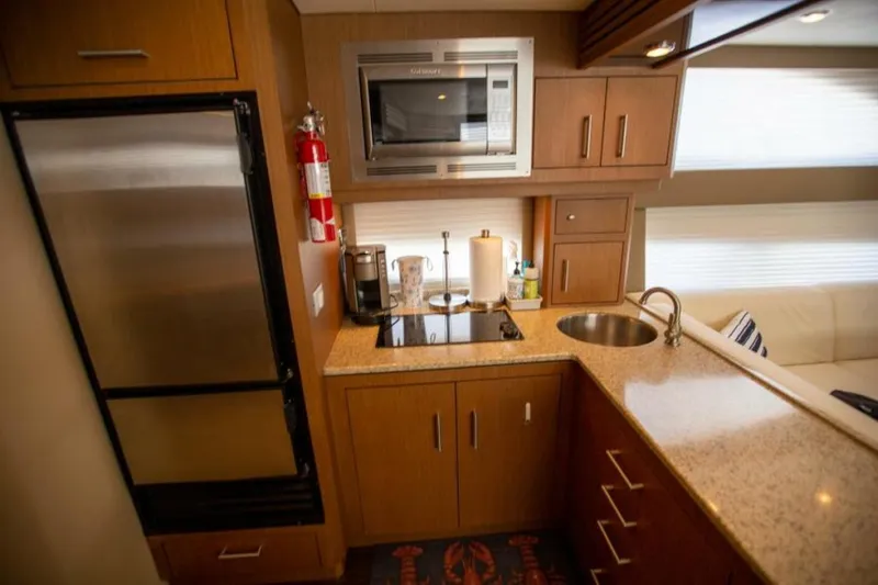 Slide: The Image of Compact kitchen in 2012 Carver Sojourn yacht with modern appliances and wooden cabinetry. - 7