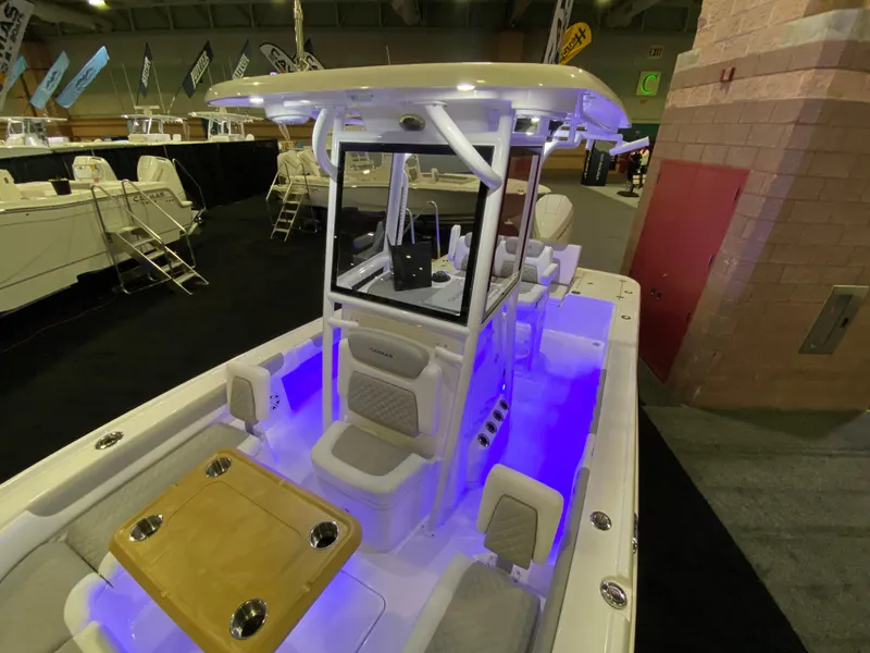 Slide: The Image of 2025 Caymas 26 HB boat with illuminated interior at a boat show. - 10