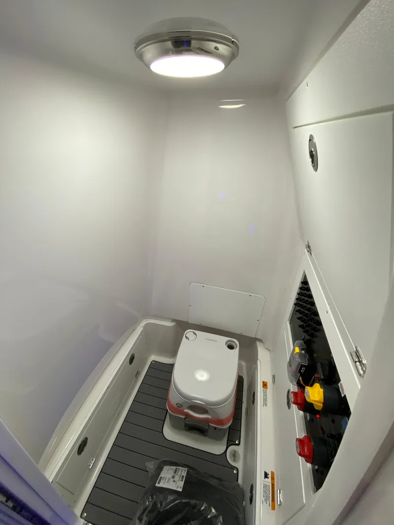 Slide: The Image of 2025 Caymas 26 HB boat interior with compact toilet and storage area. - 11