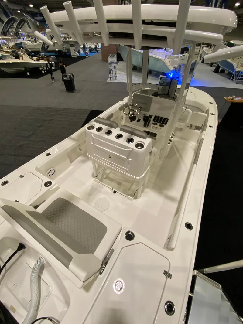 Slide: The Image of 2025 Caymas 26 HB boat interior with modern console and seating at a boat show. - 5