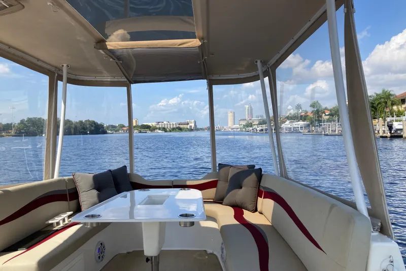 Slide: The Image of 2019 ElectraCraft 182TR boat interior with waterfront view, featuring comfortable seating and table. - 13
