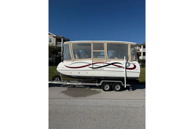 Slide: The Image of 2019 ElectraCraft 182TR boat on trailer, featuring enclosed cabin and sleek design. - 2