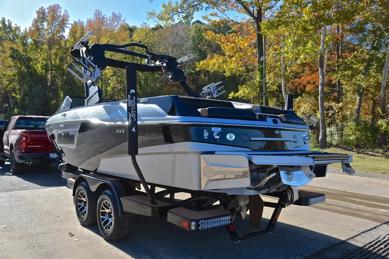 Slide: The Image of 2023 Malibu Wakesetter 23 LSV boat on trailer, parked near autumn trees. - 12