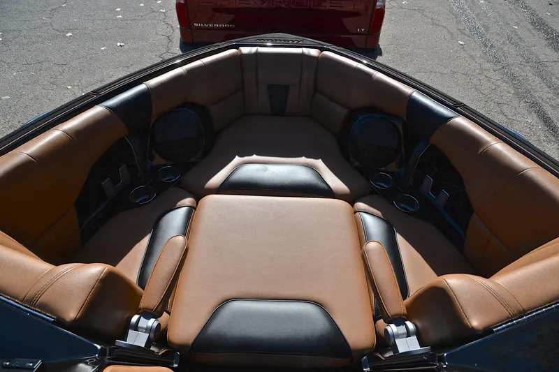 Slide: The Image of 2023 Malibu Wakesetter 23 LSV interior with tan and black seating, cup holders, and speakers. - 22