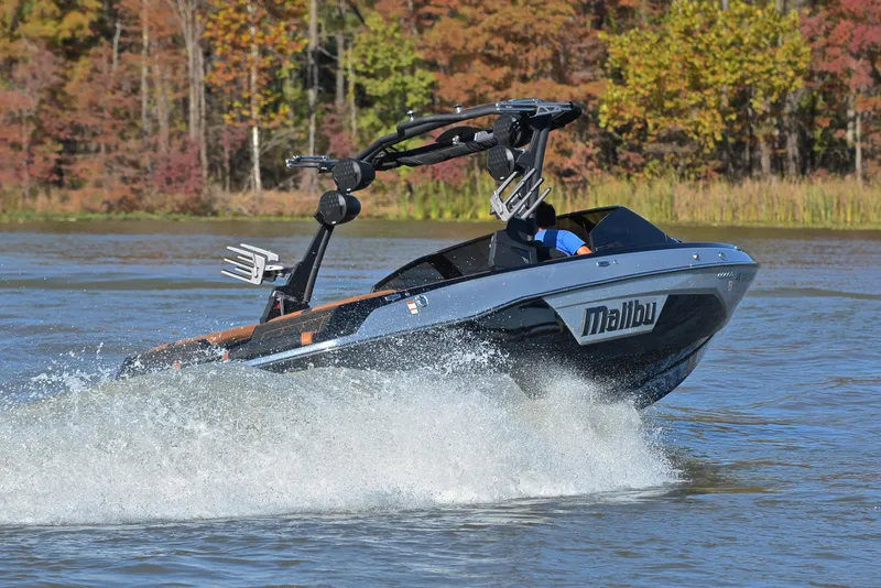 Slide: The Image of 2023 Malibu Wakesetter 23 LSV speeding on a lake with autumn foliage backdrop. - 5