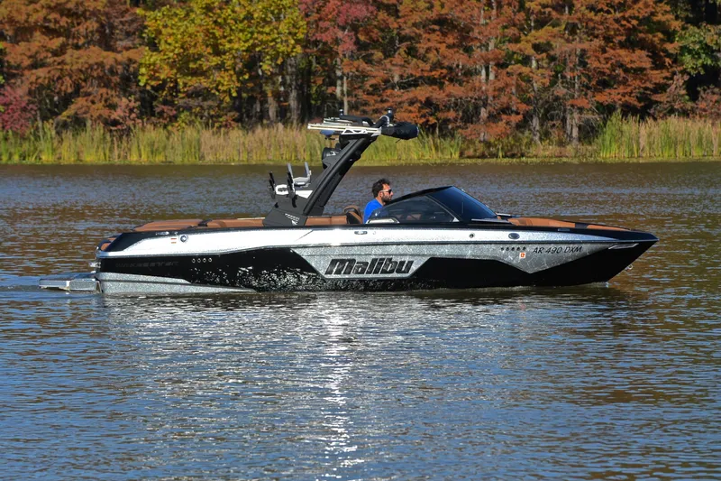 Slide: The Image of 2023 Malibu Wakesetter 23 LSV boat cruising on a serene lake with autumn foliage. - 7