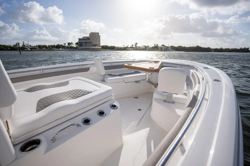 Slide: The Image of 2025 Caymas 291 boat interior with seating and table, on a sunny day by the water. - 1