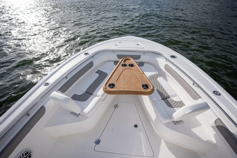 Slide: The Image of 2025 Caymas 291 boat bow with seating and triangular table on water. - 10