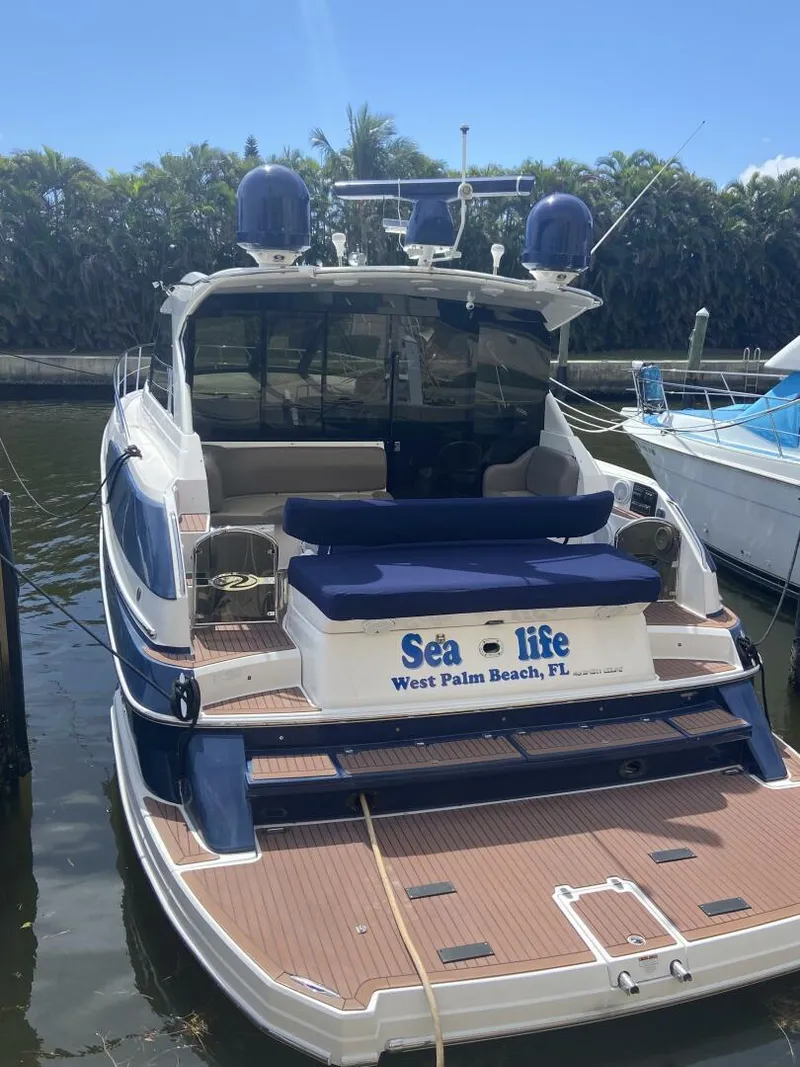Slide: The Image of 2011 Regal 46 Sport Coupe yacht docked, West Palm Beach, FL, with "Sea Life" nameplate. - 2
