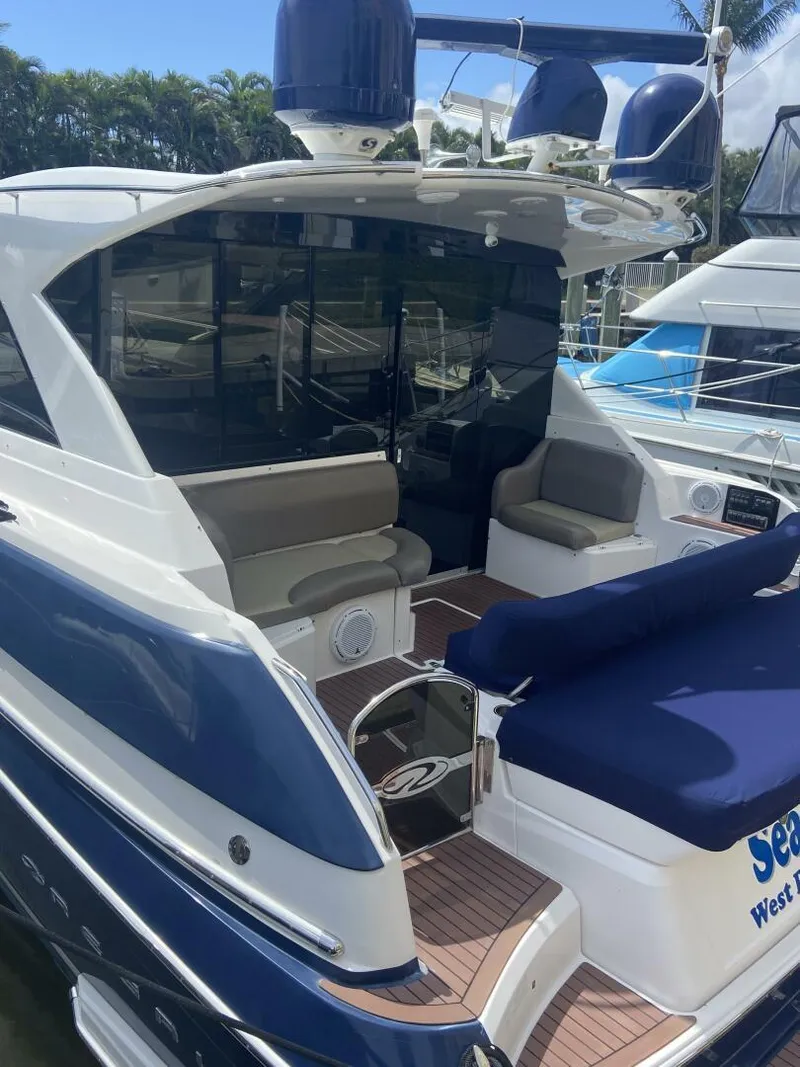 Slide: The Image of 2011 Regal 46 Sport Coupe yacht with blue and white exterior, docked at a marina. - 3