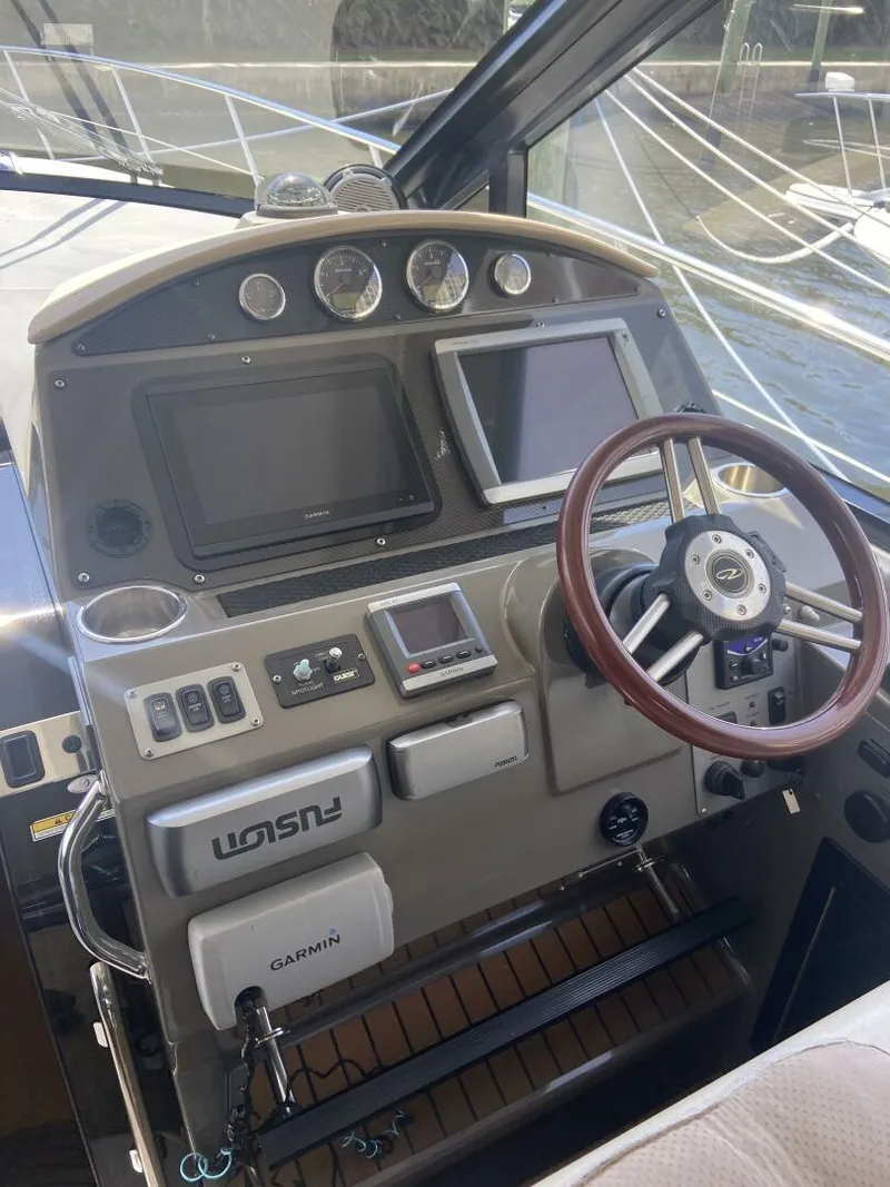 Slide: The Image of 2011 Regal 46 Sport Coupe helm with modern navigation equipment and wooden steering wheel. - 7