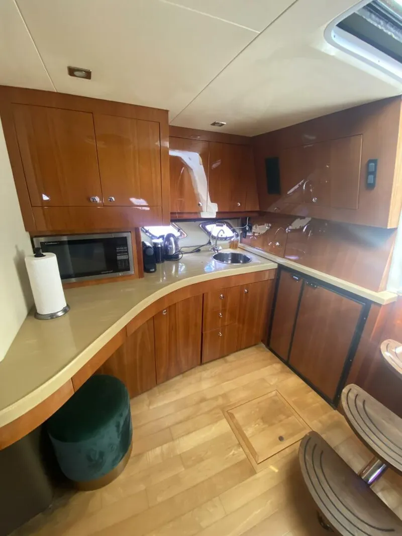 Slide: The Image of 2011 Regal 46 Sport Coupe yacht kitchen with wooden cabinetry and modern appliances. - 8