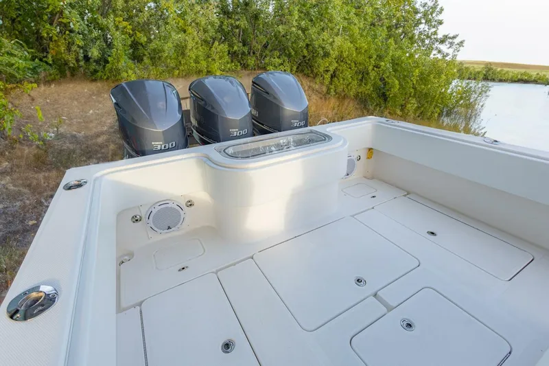 Slide: The Image of 2012 Invincible 36 Open Fisherman boat with triple Yamaha 300 engines, docked near lush greenery. - 15