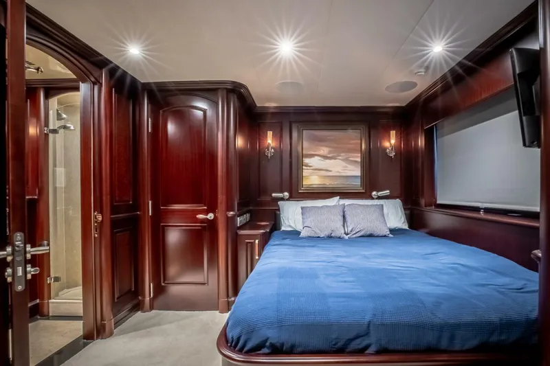 Slide: The Image of Luxurious yacht bedroom with rich wood paneling, blue bedding, and elegant lighting. Horizon Model Tri-Deck 2009. - 24