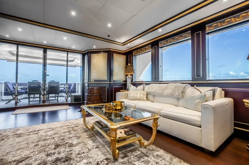 Slide: The Image of Luxurious yacht interior with elegant decor, featuring a plush sofa and glass coffee table. Horizon Model Tri-Deck 2009. - 4
