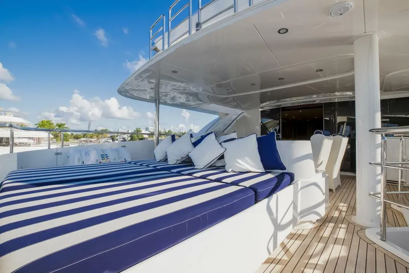 Slide: The Image of Luxurious 2009 Horizon Model Tri-Deck yacht with striped sunbeds and plush cushions. - 49