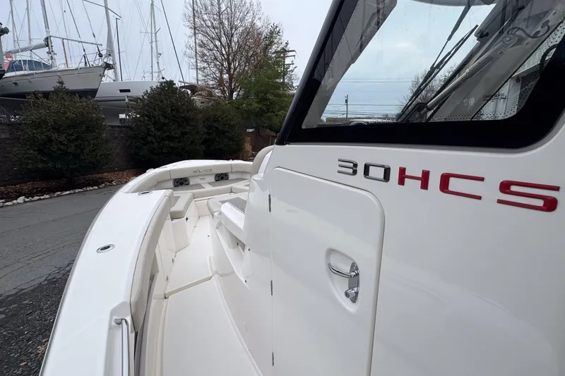 Slide: The Image of 2025 Solace 30 HCS boat, sleek white design, docked near other vessels. - 17