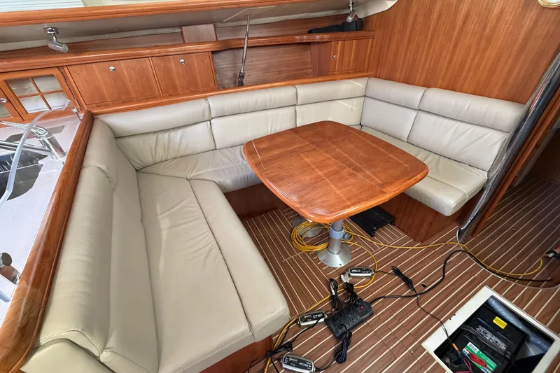 Slide: The Image of Interior of 2003 Hunter 44 Deck Salon with wood table and beige seating. - 15