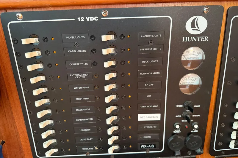 Slide: The Image of Control panel of a 2003 Hunter 44 Deck Salon yacht, featuring various switches and gauges. - 19
