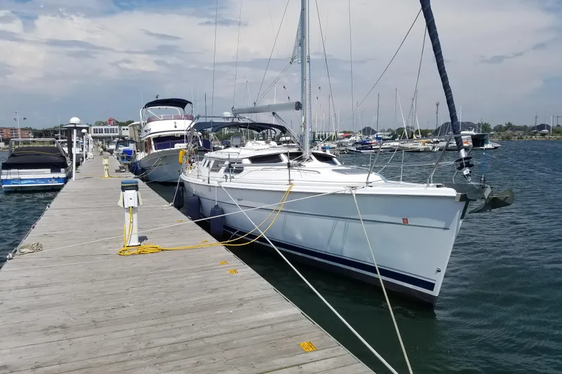 Slide: The Image of 2003 Hunter 44 Deck Salon yacht docked at marina, clear sky, calm water. - 2