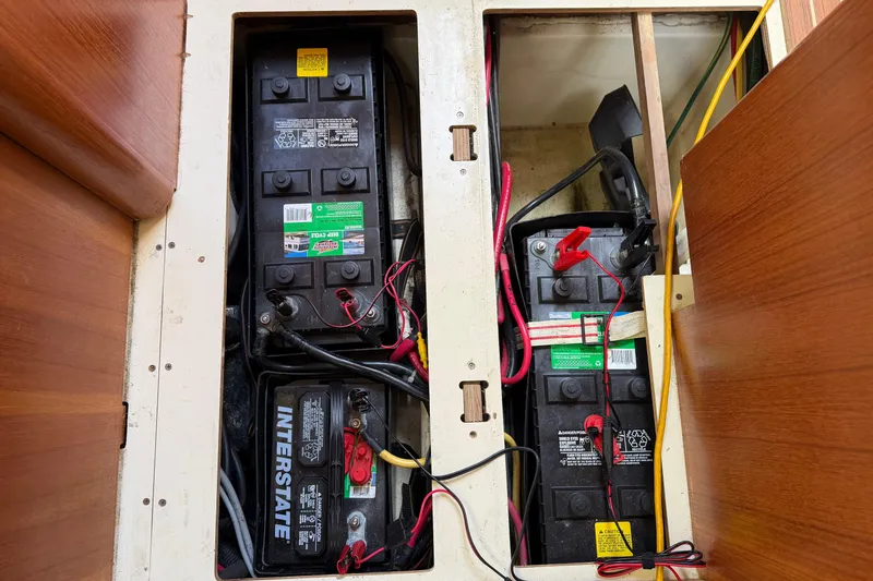 Slide: The Image of Battery compartment of a 2003 Hunter 44 Deck Salon sailboat, showing multiple batteries and wiring. - 25