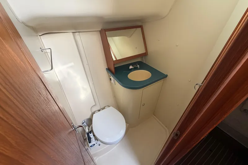 Slide: The Image of Compact bathroom in 2003 Hunter 44 Deck Salon yacht with toilet, sink, and mirror. - 31