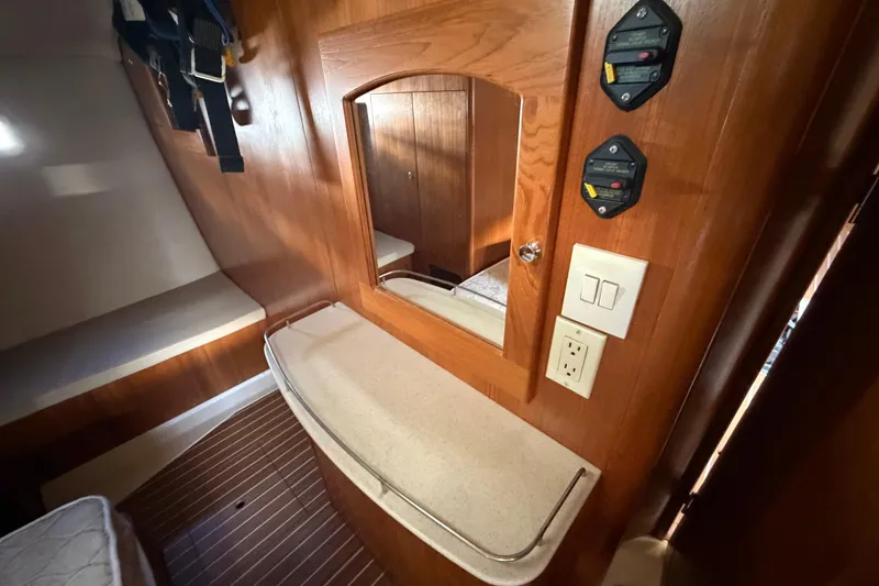 Slide: The Image of 2003 Hunter 44 Deck Salon interior with wood finish, mirror, and electrical panel. - 34