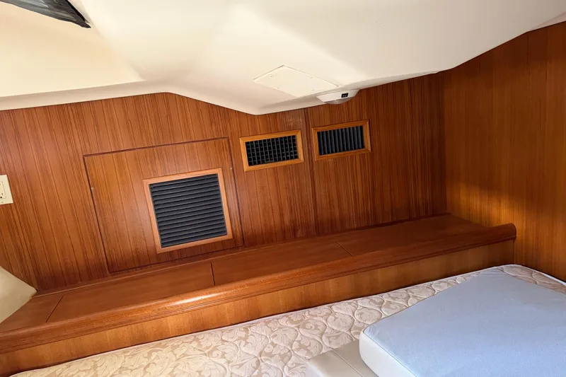 Slide: The Image of Interior cabin of 2003 Hunter 44 Deck Salon with wood paneling and bedding. - 35
