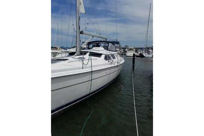 Slide: The Image of 2003 Hunter 44 Deck Salon sailboat docked in a marina, side view. - 4