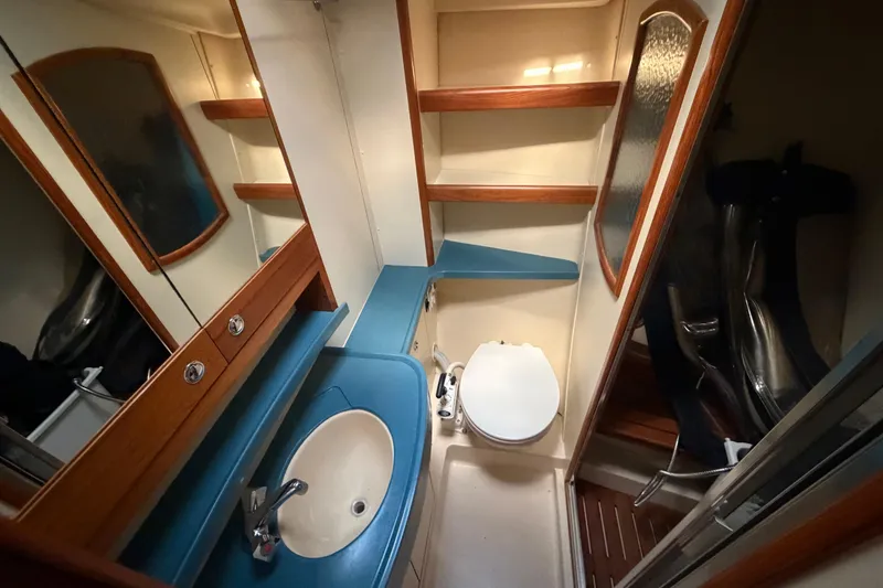 Slide: The Image of Bathroom interior of 2003 Hunter 44 Deck Salon yacht, featuring sink, toilet, and wooden accents. - 45