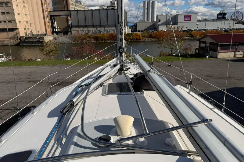 Slide: The Image of 2003 Hunter 44 Deck Salon sailboat docked near industrial buildings and river. - 64