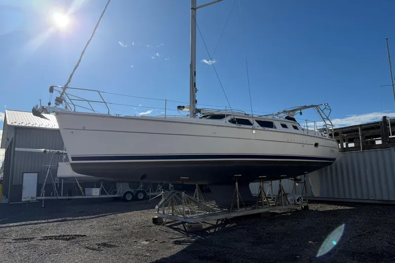 Slide: The Image of 2003 Hunter 44 Deck Salon sailboat on dry dock under clear blue sky. - 7