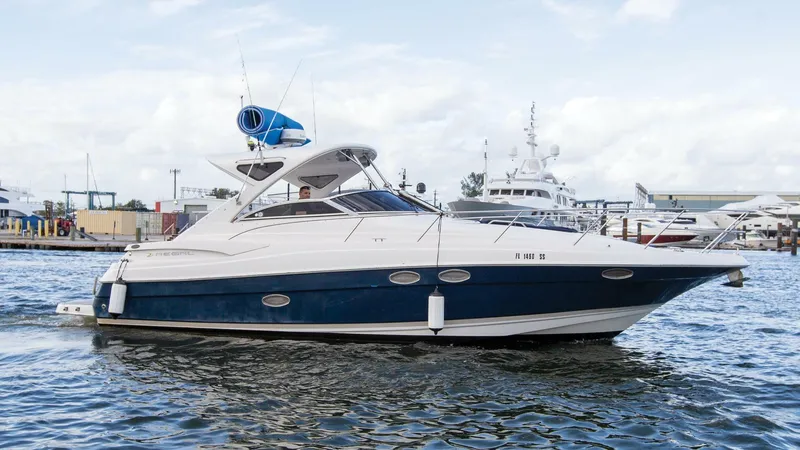 The Image of 2008 Regal 38 yacht on water, docked at marina with other boats. - 1