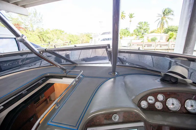 Slide: The Image of 2008 Regal 38 boat dashboard with gauges, open hatch, and tropical background. - 16