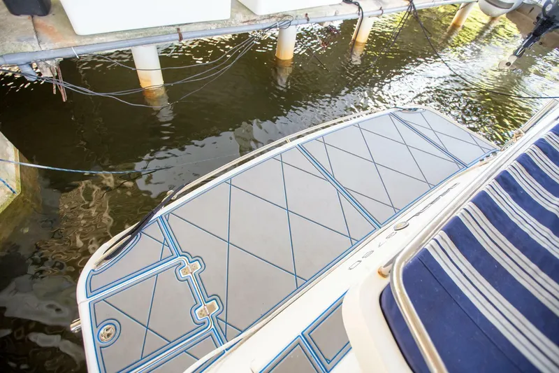 Slide: The Image of 2008 Regal 38 boat deck with blue accents, docked in calm water. - 20