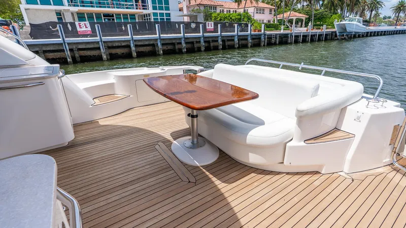 Slide: The Image of 2008 Sea Ray Sundancer yacht deck with seating and table, docked by waterfront homes. - 27
