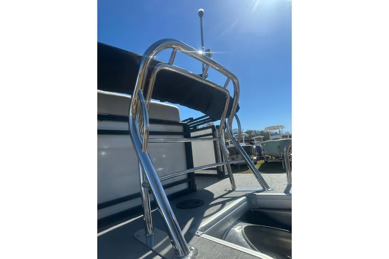 Slide: The Image of Stainless steel ladder on 2026 Godfrey Sweetwater 2286 Cruise Special Edition boat under clear sky. - 32