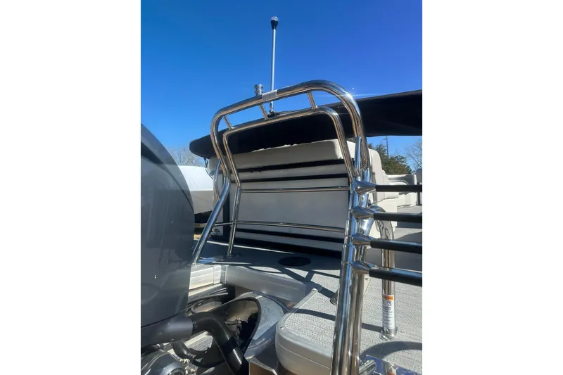 Slide: The Image of 2026 Godfrey Sweetwater 2286 Cruise Special Edition boat ladder and seating, under clear blue sky. - 34