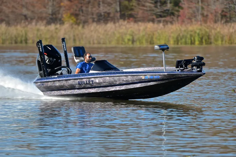 The Image of 2023 Bullet 21XRS boat speeding on a lake with a driver in blue shirt. - 1