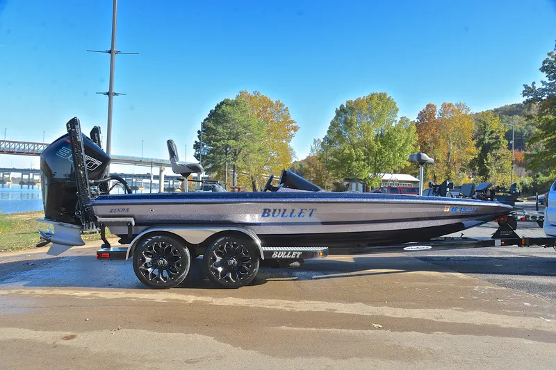 Slide: The Image of 2023 Bullet 21XRS boat on trailer by a lakeside, surrounded by autumn trees. - 15