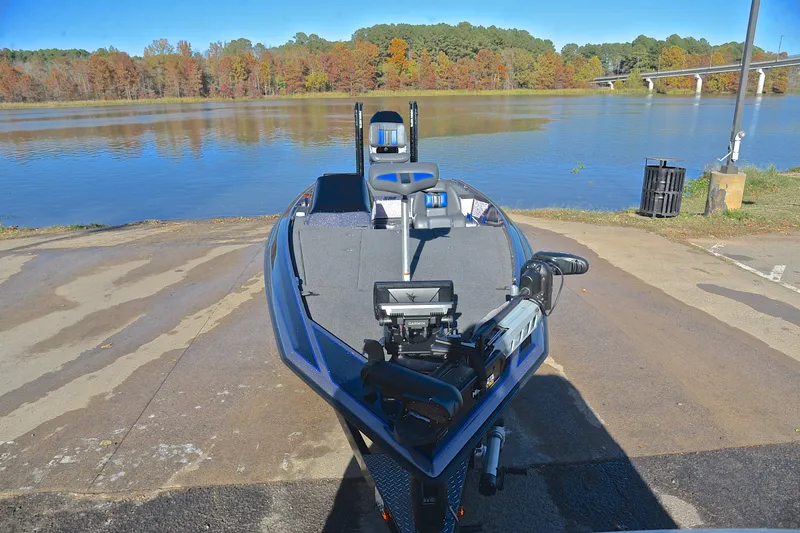 Slide: The Image of 2023 Bullet 21XRS boat at lakeside launch ramp with autumn trees in background. - 17